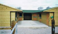 U Shaped Stable Yard, with 2 x corner units, 3 x loose boxes, a hay store / wash box, and a feed store. Green onduline completes the look.