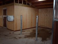 View of T&G lining boards and metal framed tack room door with hardwood infill.