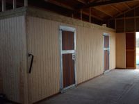 Metal framed tack room doors with hardwood infill. Set into vertical T&G boarding.